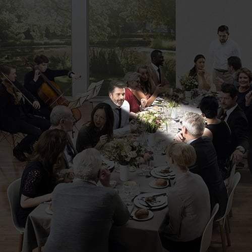 darkened image of people sitting in a dining room with a small section in light representing focused hearing