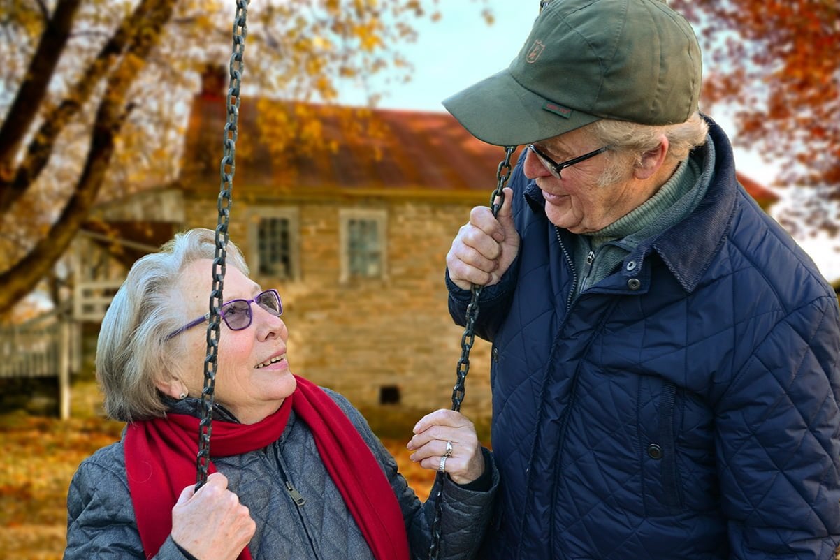 A man wearing a hat and looking at his wife