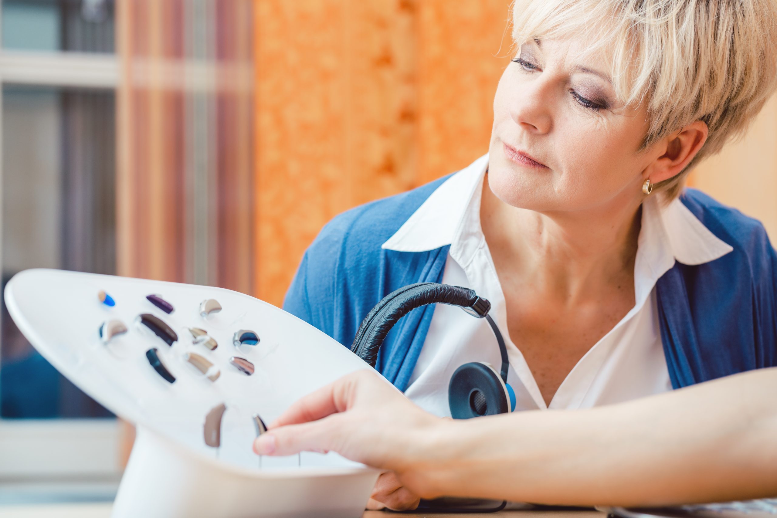 Senior woman with impairment choosing hearing aid